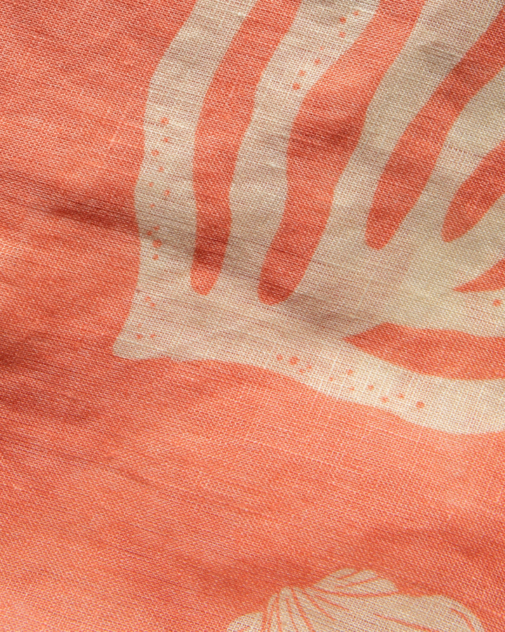 Close-up of the LSPACE Mallorca Dress in Shell Or High Water, highlighting the fabric detail with white shell and coral reef motifs on a dusty coral background.