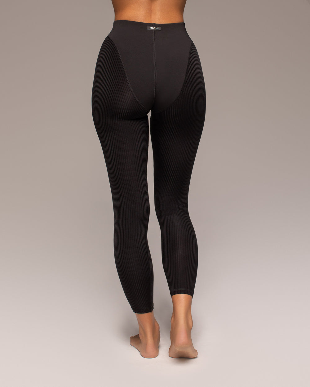Black leggings worn by a person on a plain background
