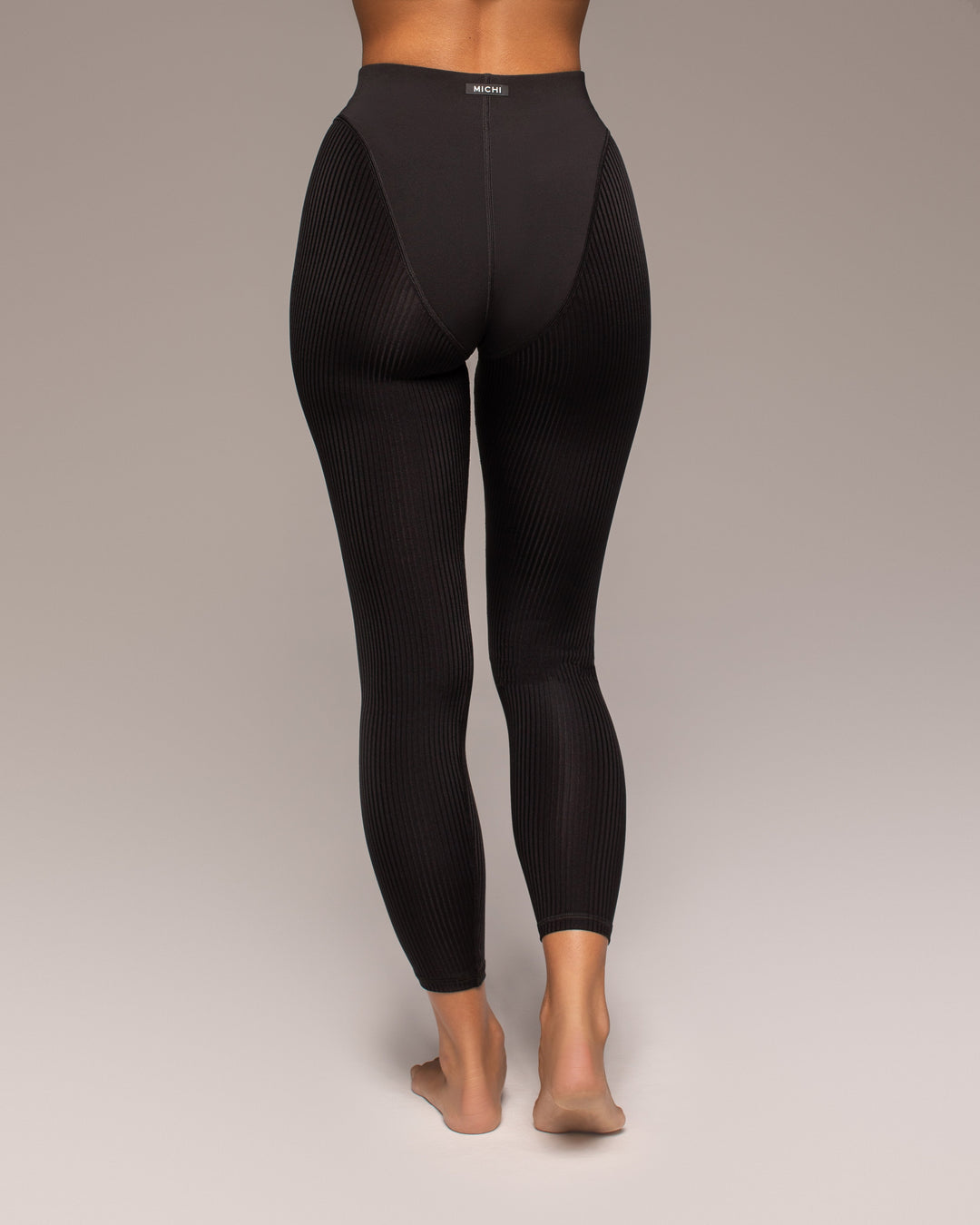 Black leggings worn by a person on a plain background