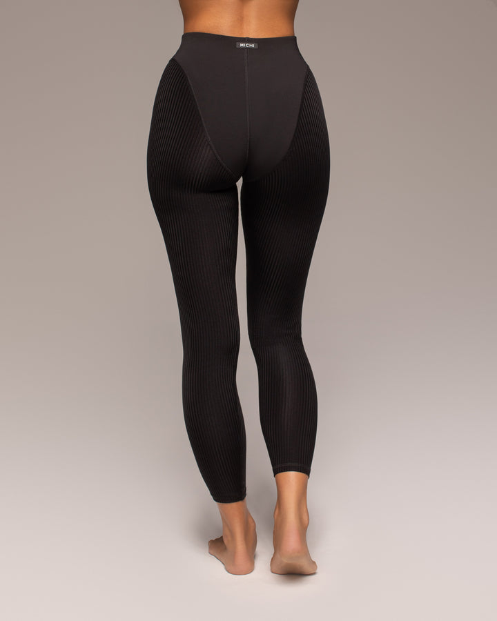 Black leggings worn by a person on a plain background
