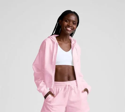 Person wearing a pink tracksuit on a plain background