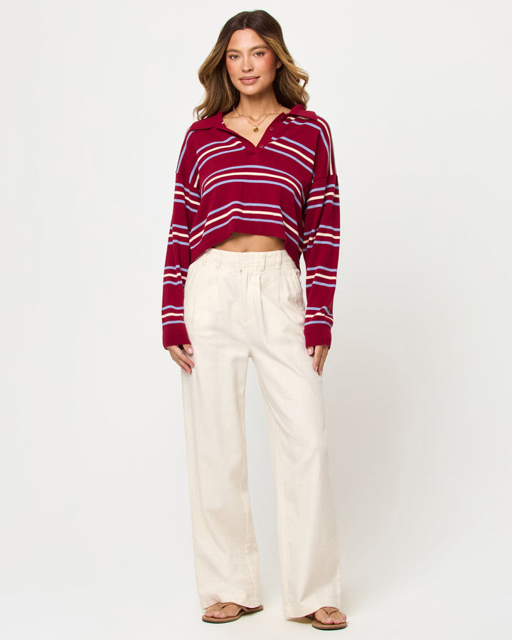 LSPACE Dalton sweater in berry wine stripe, styled with pants, front view on model.