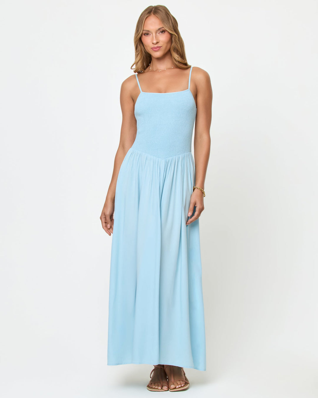 Front view of a model wearing the LSPACE Misha Midi in Tourmaline, showing the powder blue smocked bodice, thin spaghetti straps, and full gathered midi skirt.