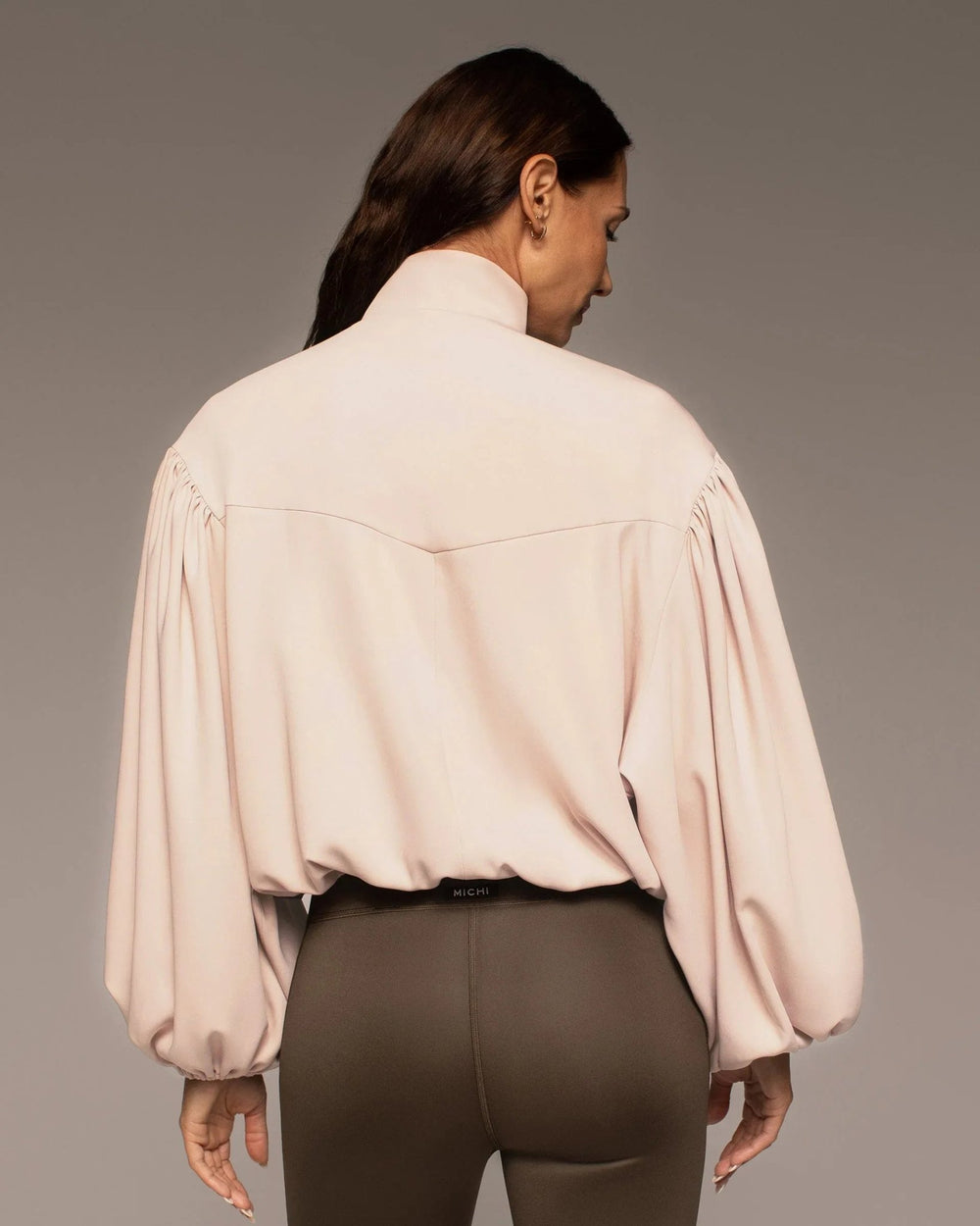 Back view of the Onyx Jacket in Nude Pink with a relaxed silhouette