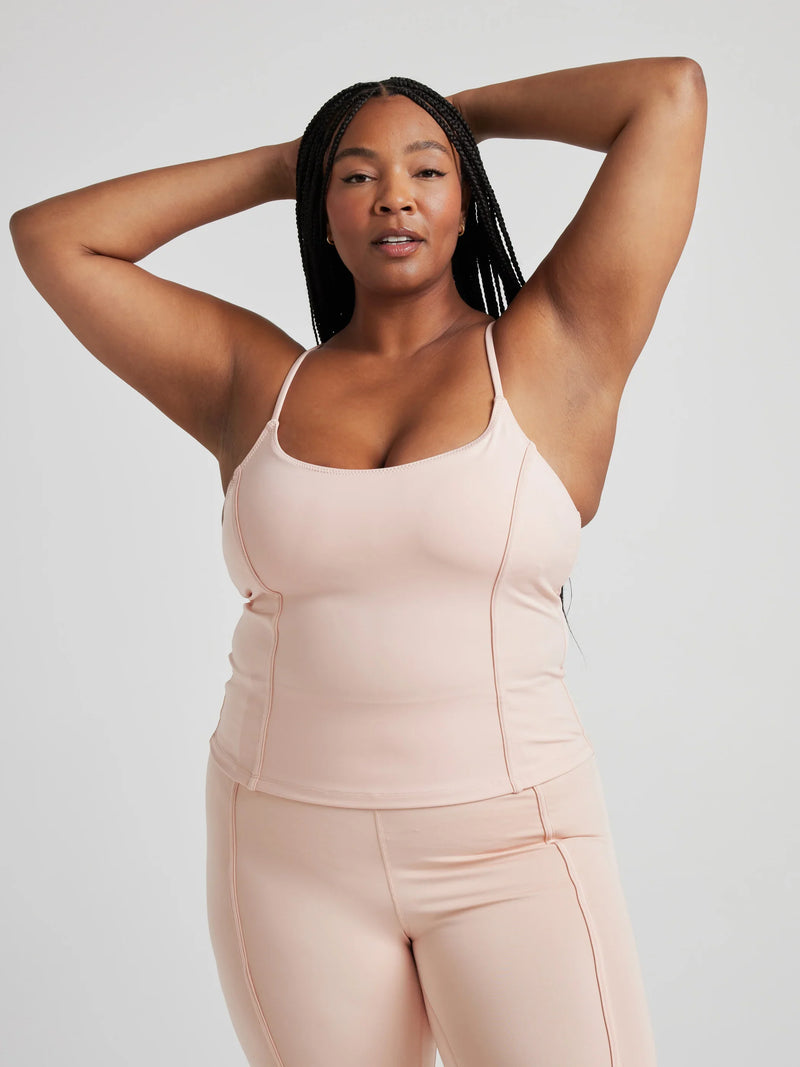 model poses in ballet-pink corset tank