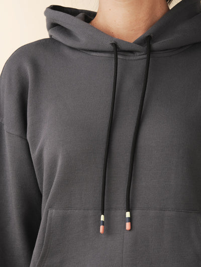 model wears cozy sustainable hoodie with pocket in grey