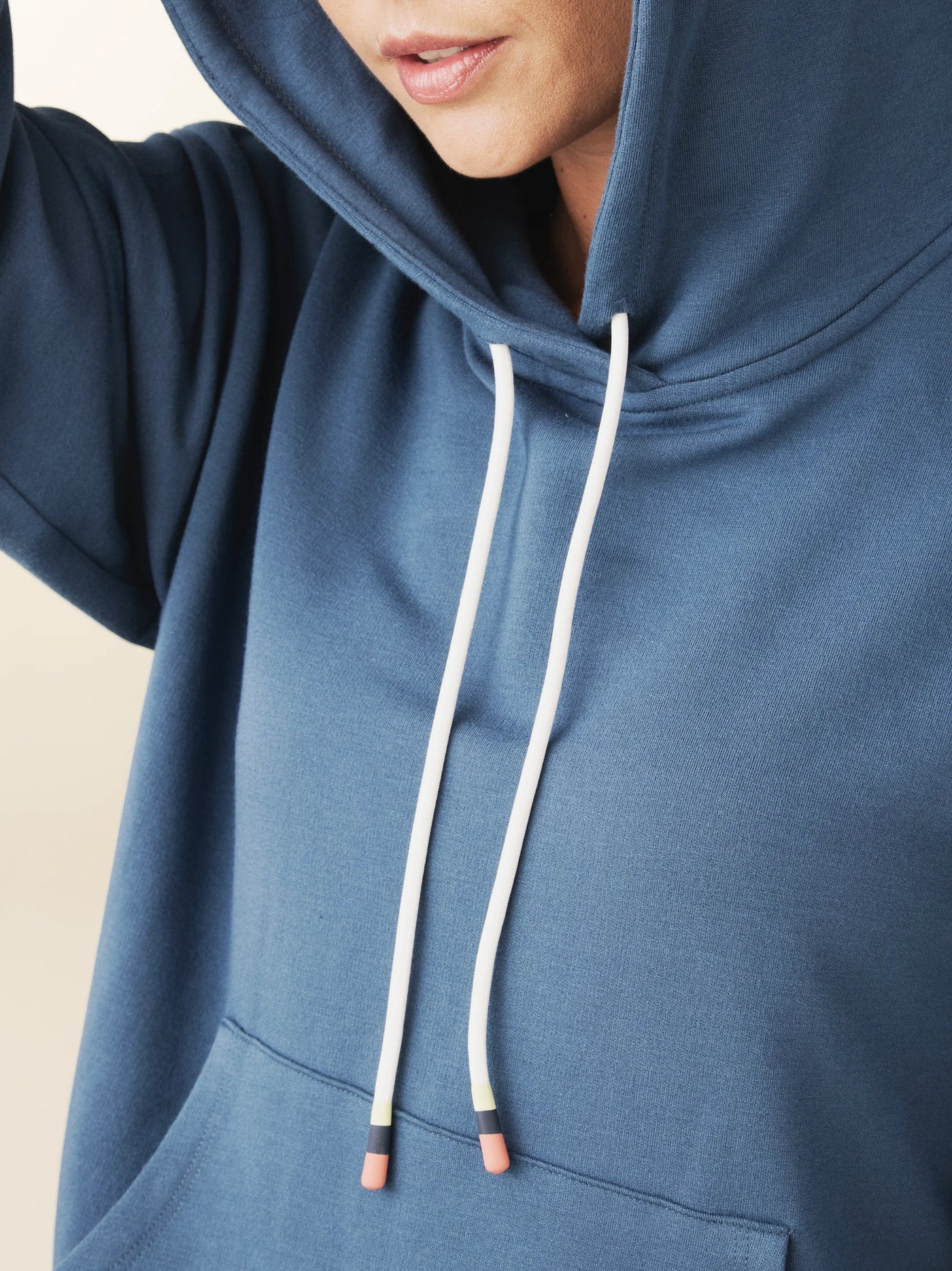 model wears cozy sustainable hoodie with pocket in blue