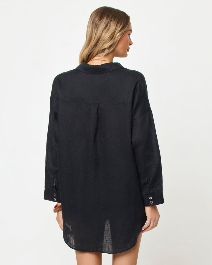 Back view of a black oversized button-down shirt dress showing relaxed fit and long sleeves